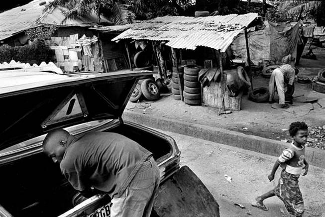 Bissau, Janeiro de 2005, taxista num posto de venda/reparao de pneus. Foto de Ernst Schade