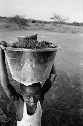 Farim, 2005, criana transportando lodo para produo de sal. Foto de Ernst Schade